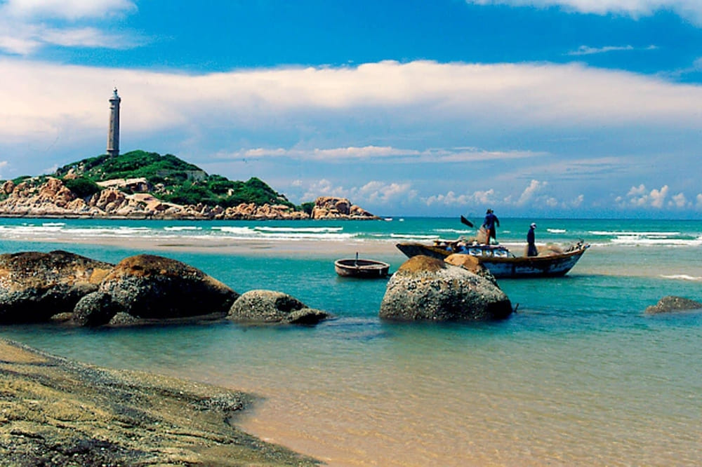 Ke Ga Beach's historic French lighthouse standing majestically on the rocky island with turquoise waters surrounding
